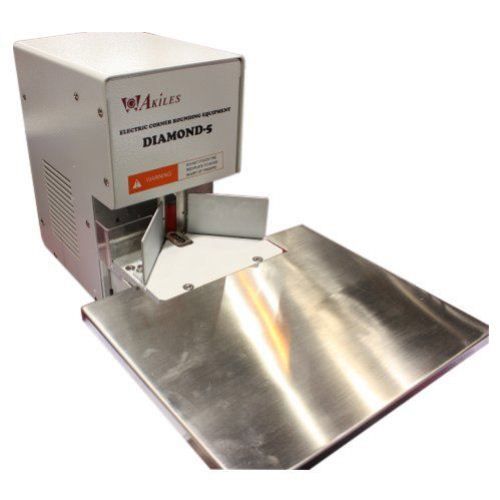 An Akiles Diamond 5 Commercial Duty Electric Corner Rounding Machine with a sturdy design and stainless steel table for professional corner rounding applications.