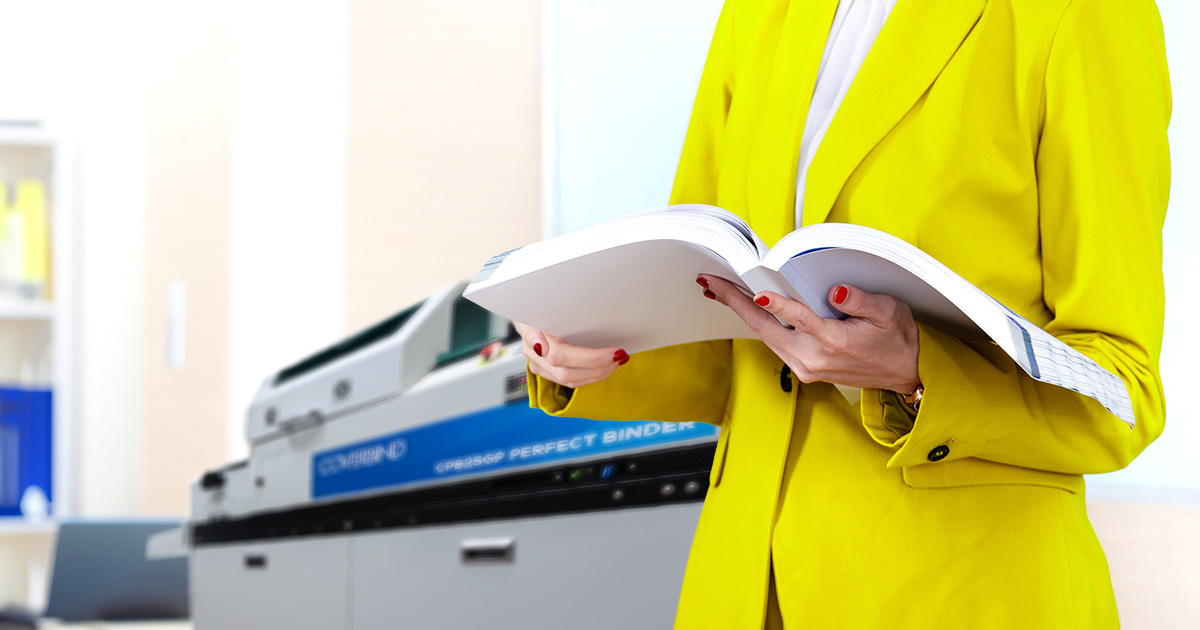 Office admin holding a bound book from a Perfect Binding Machine