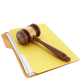 Wooden gavel resting on a stack of documents inside a yellow file folder, representing Office Supplies for Correctional Facilities used in legal and administrative processes.